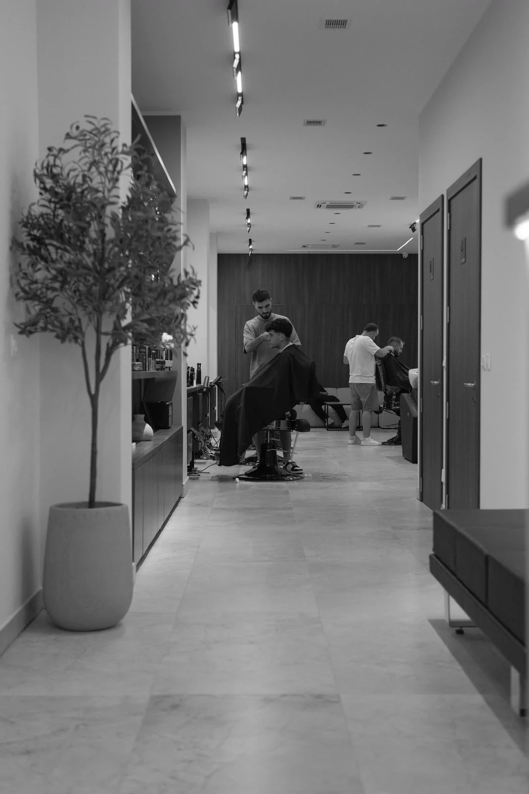 The length of the studio with two barbers at work.