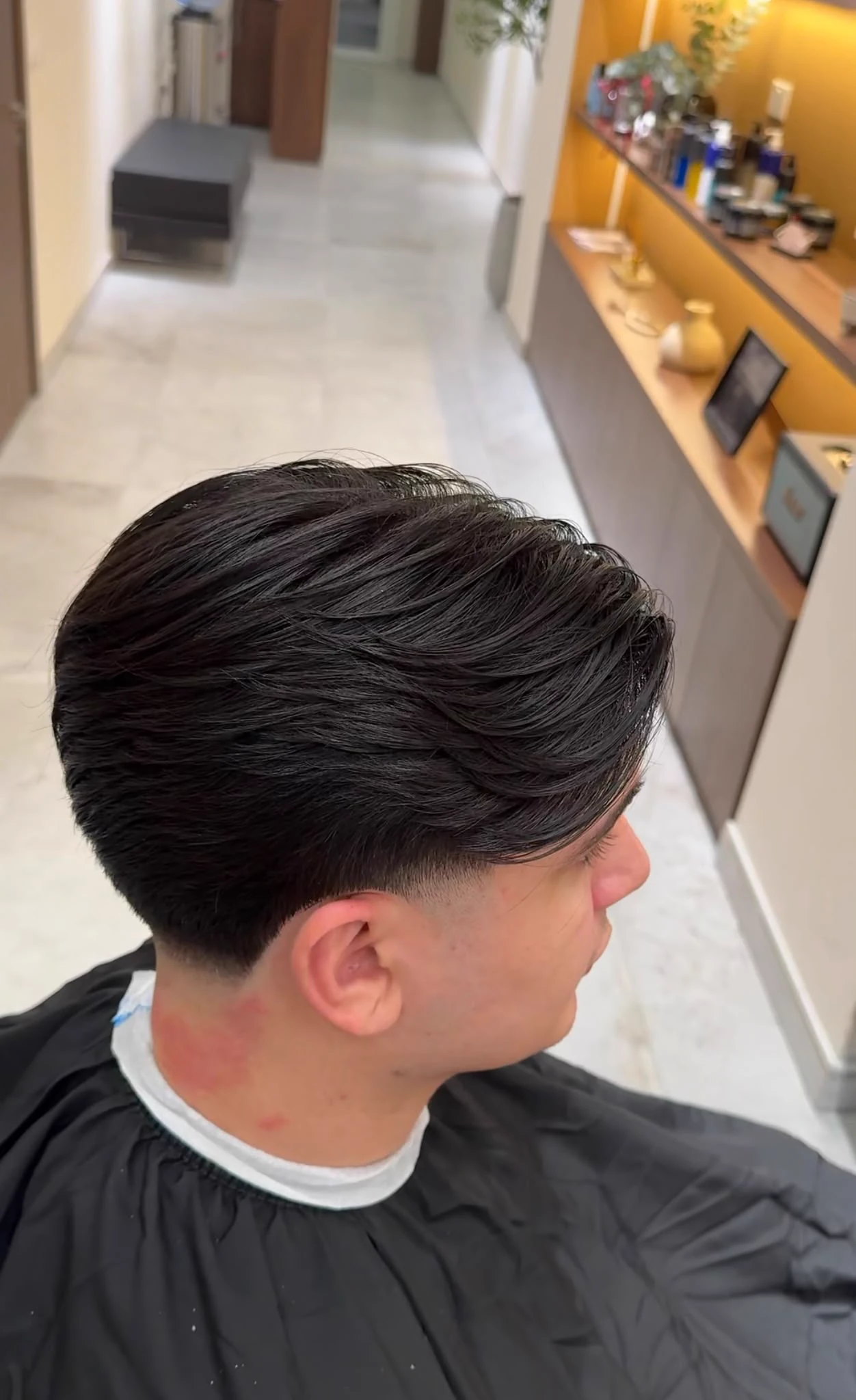A finished cut with a soft textured flow, seen from behind in the chair.