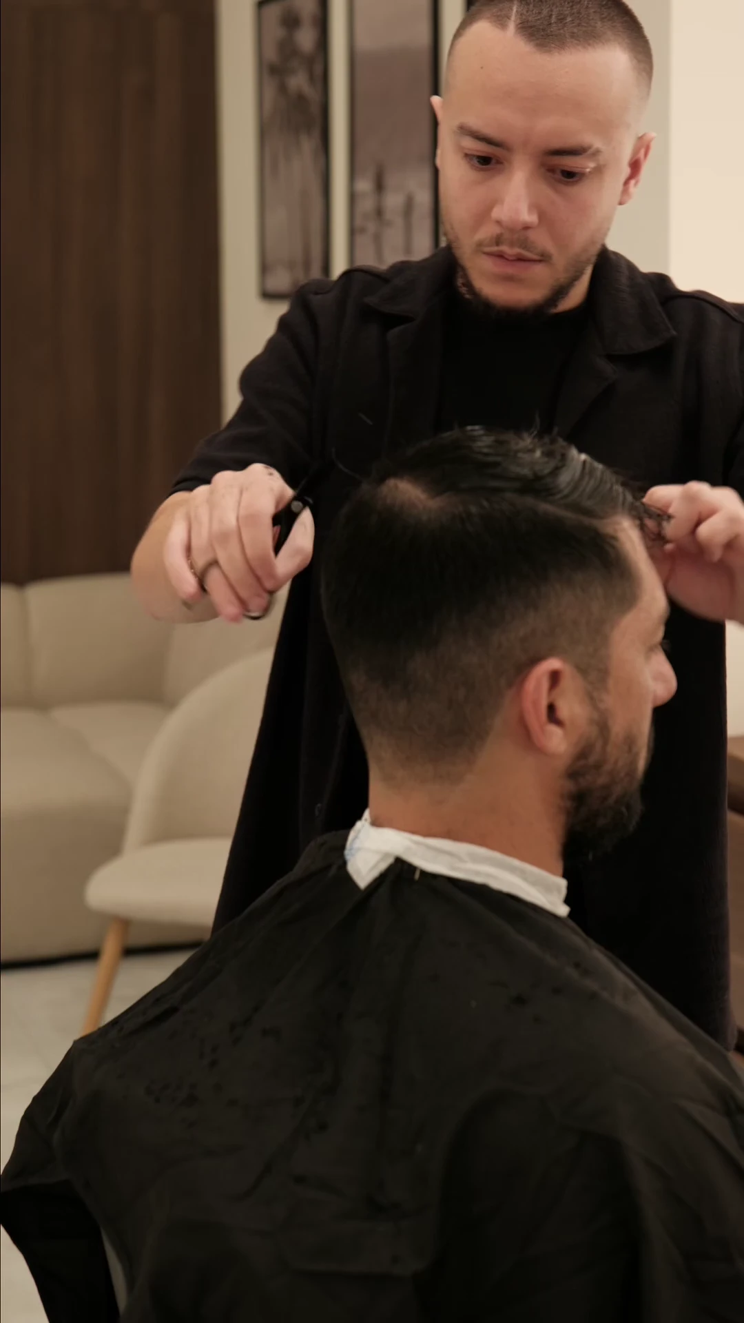 A barber working scissors through a client's hair at DS Barber Studio.