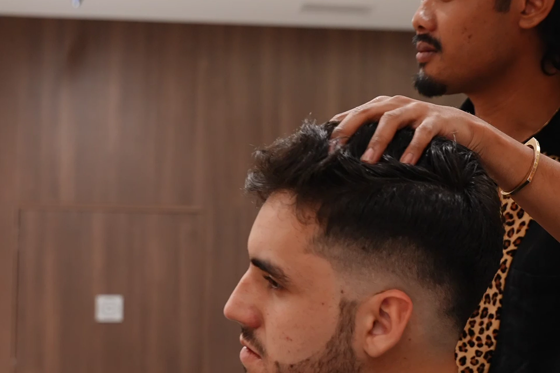 A barber at work on a client in the chair at DS Barber Studio.